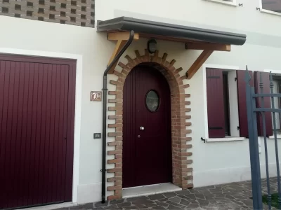 Lamellar wooden door covers projecting roofs