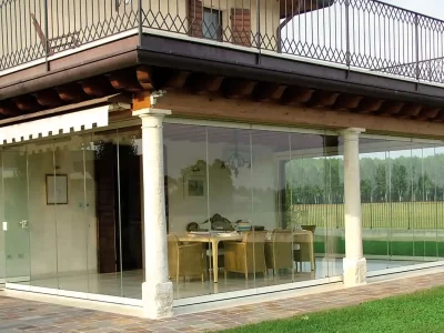 Lamellar wooden structure with stone columns and sliding glass